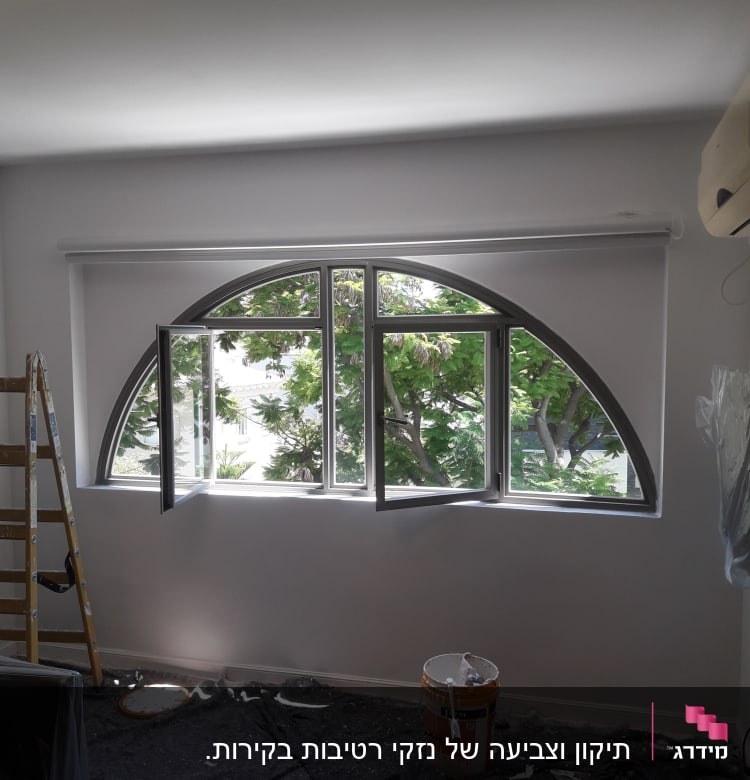 סולם, דלי צבע ומברשת על רצפה מכוסה בניילון